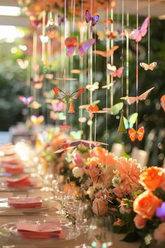 a long table topped with lots of flowers and butterflies hanging from it's ceiling