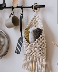 a kitchen towel hanging on the wall with utensils and spoons in it