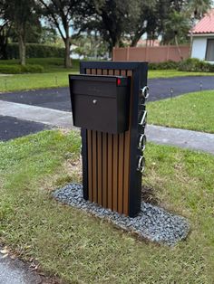 there is a mailbox in the middle of some grass and rocks on the ground