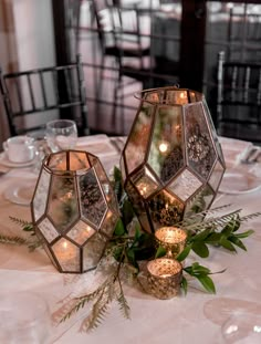 two glass lanterns sitting on top of a table