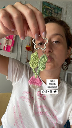 a woman is holding up some crocheted items