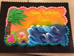 a birthday cake decorated with an image of the ocean and palm trees, on a table