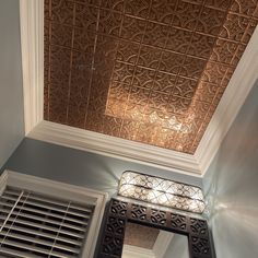 the ceiling in this room is decorated with intricate metal designs and decorative lighting fixture, along with an ornate window