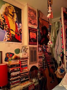 a room filled with lots of music memorabilia and posters on the wall, along with a guitar