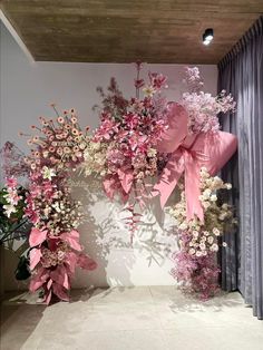 pink and white flowers are arranged on the wall