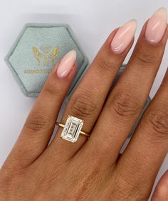 a woman's hand with a ring on it and a baguette in the background