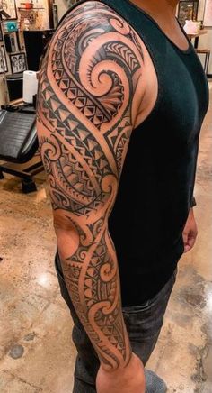 a man with a black and grey tattoo on his arm is standing in a store