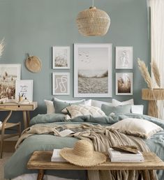 a bedroom with blue walls and pictures on the wall above the bed, along with a wooden coffee table