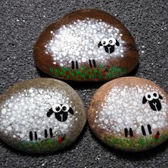 three painted rocks with sheep on them sitting on the ground in front of each other