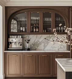 a kitchen with marble counter tops and wooden cabinets, along with a coffee maker on the far wall