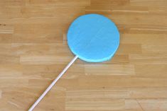 a blue lollipop sitting on top of a wooden floor