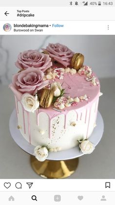 a cake with pink frosting and flowers on top is sitting on a gold plate