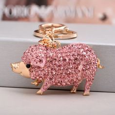 a pink pig keychain sitting on top of a box