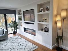 a living room filled with furniture and a fire place next to a wall mounted tv