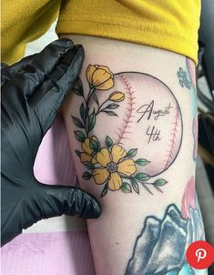 a baseball tattoo with flowers on it