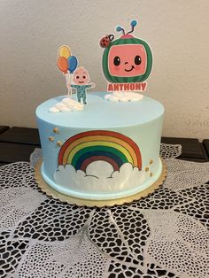 there is a cake that has an anthrony on it and balloons in the air