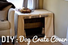 a dog crate is sitting on the floor next to a chair with a blanket over it