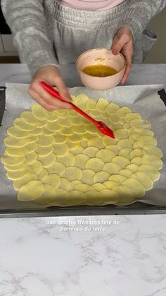 a person holding a bowl and chopsticks in front of a cake