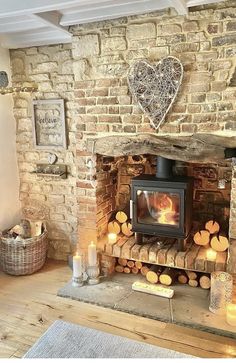 a living room with a fire place in the middle of it and candles on the floor