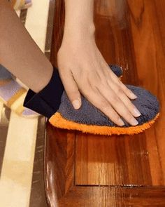 a person cleaning a wooden floor with a cloth