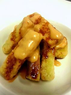 a white plate topped with french toast covered in caramel sauce