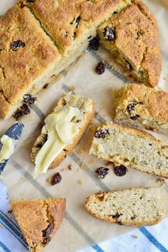 a loaf of bread with raisins and butter next to it on a piece of paper