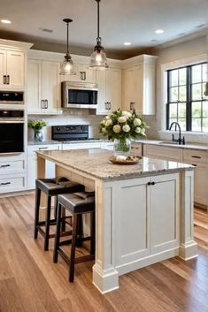 a large kitchen with an island and two stools next to it on a hard wood floor