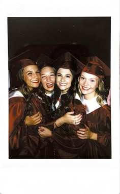 a group of young women standing next to each other wearing graduation caps and gowns