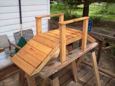 a chair made out of wood sitting on top of a wooden bench next to a tree