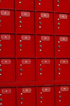 many red mail boxes are stacked on top of each other