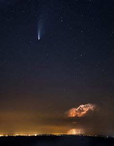 the night sky is lit up with stars and bright lights, as well as some clouds