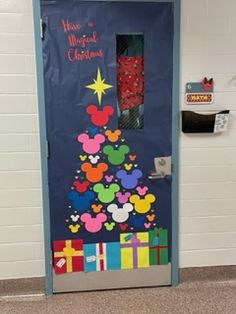 a door decorated to look like a christmas tree with mickey mouses on it and presents