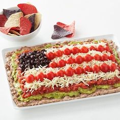 an american flag pizza on a platter with chips and salsa in the bowl next to it