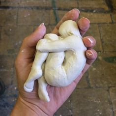 a person holding a fake human heart in their left hand on the ground next to a brick walkway