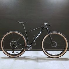 a black and white bike parked in front of a gray wall