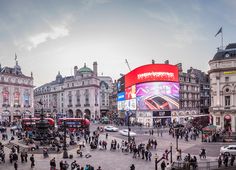 a busy city square with lots of people walking around