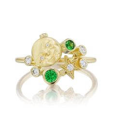 a gold ring with green and white stones