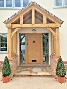 the front entrance to a house with potted plants