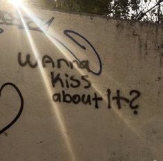 graffiti written on the side of a wall that says wannan't kiss about it?