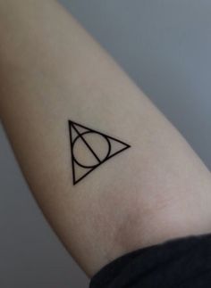 a small triangle tattoo on the wrist