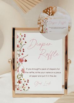 a sign that is sitting on top of a white bed with pink and yellow flowers