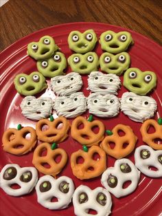 a red plate topped with lots of cookies covered in icing