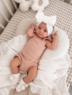 a baby laying on top of a bed in a crib