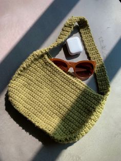 a crocheted bag with sunglasses on top of it