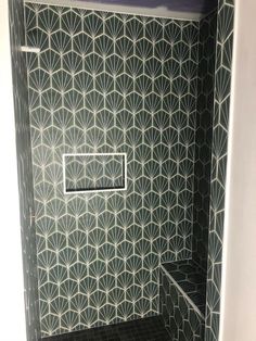 a bathroom with black and white tiles on the wall, shower stall and bathtub