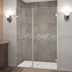 a bathroom with a walk in shower next to a sink and mirror on the wall