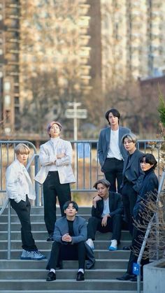 group of people standing on steps with buildings in the backgroung behind them