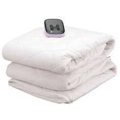 thermometer is placed on top of two white quilted bedspreads