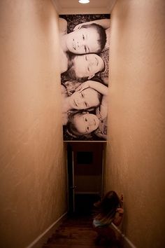 an image of two women on the wall in a hallway with stairs leading up to them