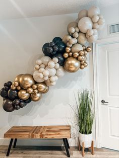 a bunch of balloons are hanging on the wall next to a bench and potted plant